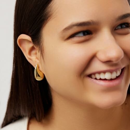 Woman smiling wearing gold earring